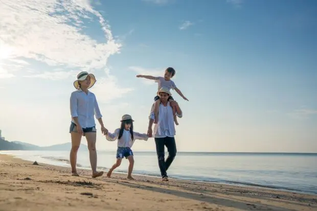 Parents with children enjoying vacation on beach