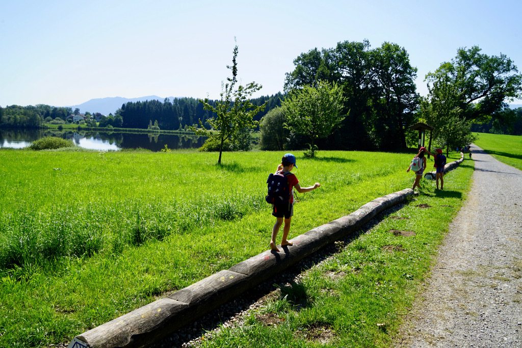 Penzberg Barfusspfad Holzstamm Kind balanciert auf dem Holzstamm
