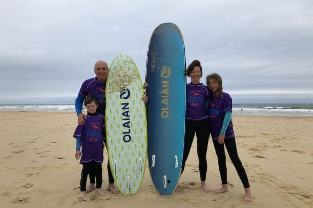 surferfamilie am strand mit surfbrettern