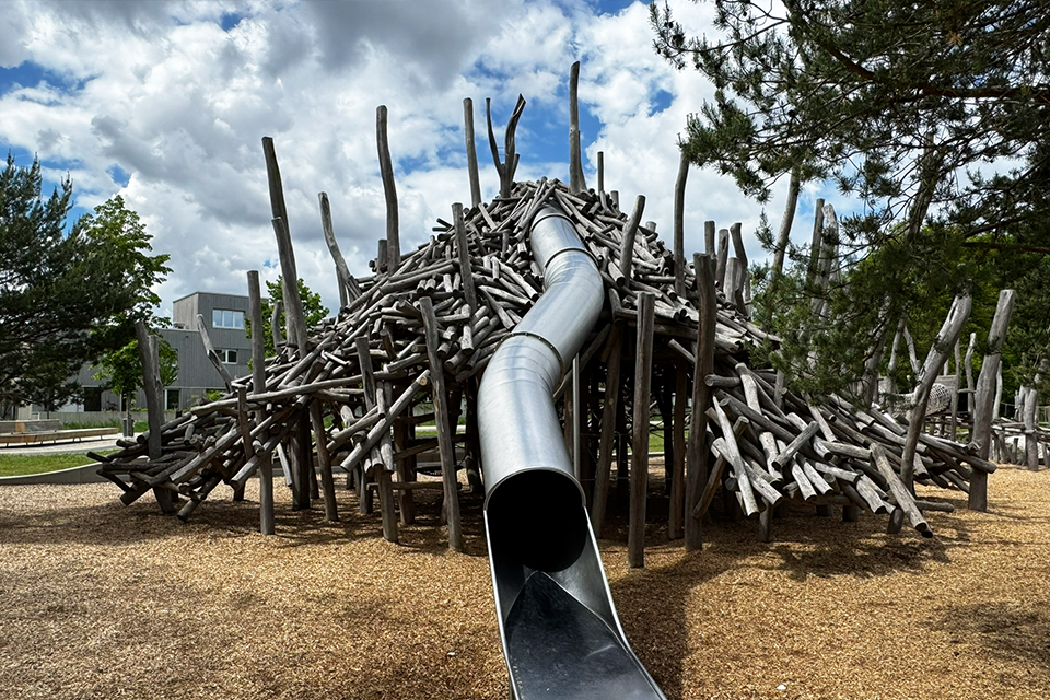 Holzspielplatz gebaut wie ein Biberberg mit Rutsche